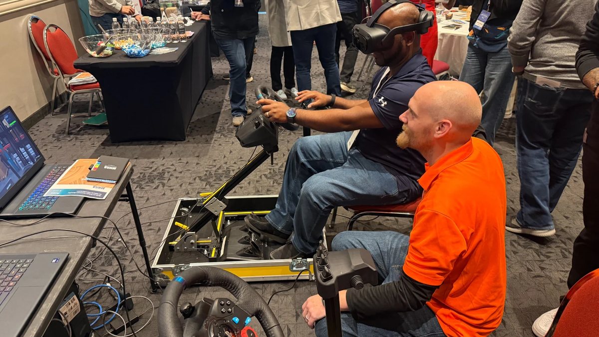 Attendees driving the Fold N Go simulator at the 2026 Manufacturing Alberta Conference